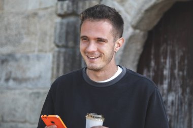 Delikanlı cep telefonunu kontrol ediyor.