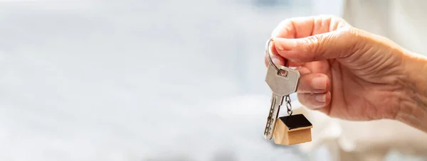 Woman holding  house key in hand.Mortgage loan approval home loan and insurance concept.