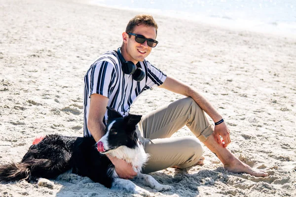 Χαλαρός Άνθρωπος Στην Παραλία Απολαμβάνοντας Σκύλο Του Και Ακούγοντας Μουσική — Φωτογραφία Αρχείου