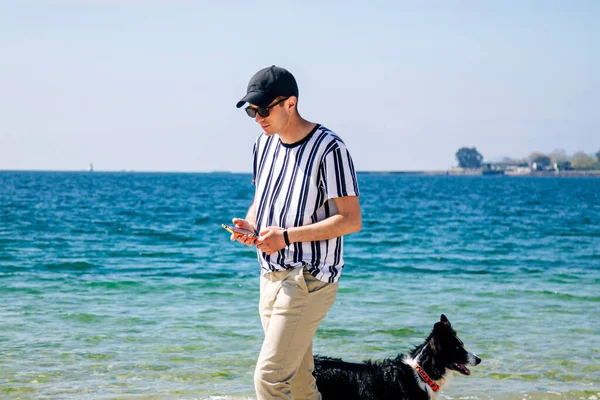 Uomo Rilassato Con Suo Cane Sulla Spiaggia Parlare Sul Cellulare — Foto Stock