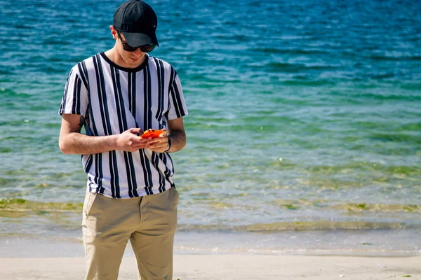 Νεαρός Άνδρας Στην Παραλία Χρησιμοποιώντας Κινητό Τηλέφωνο — Φωτογραφία Αρχείου