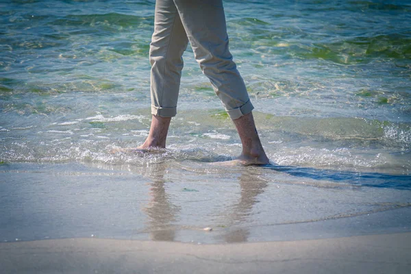 在海滩上行走的人赤脚的特写镜头 在海浪边发泡 — 图库照片