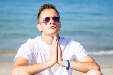 Kumsalda ruhsal egzersizler yapan rahat bir adam.