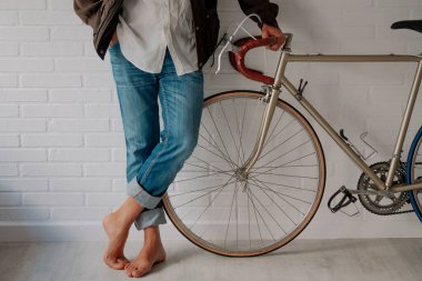 hipster with bicycle leaning against the wall in an attitude of waiting or resting