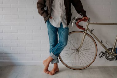 hipster with bicycle leaning against the wall in an attitude of waiting or resting
