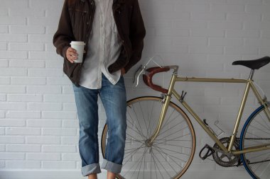 relaxed man with coffee to go and bicycle