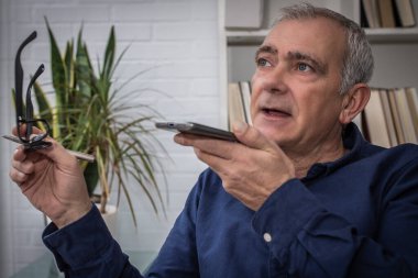 Evde akıllı telefon kullanan yetişkin adam