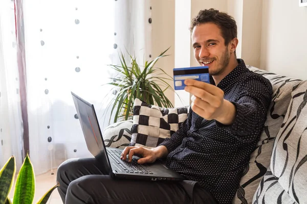 young man or student with laptop and credit card at home