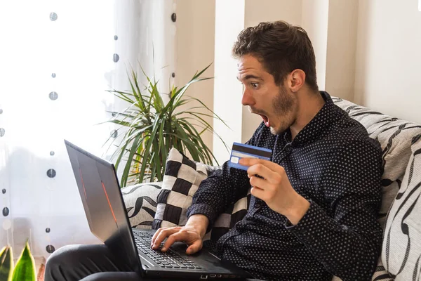 young man or student with laptop and credit card at home