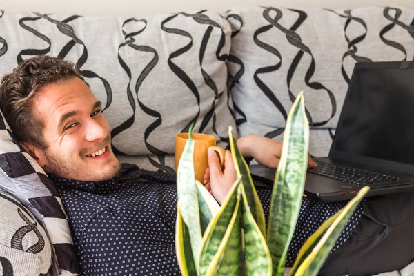 Happy Attractive Man Having Coffee Consulting His Laptop Home — Zdjęcie stockowe