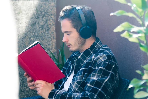 Young Man Terrace Home Reading Book Listening Music Headphones — Stock Photo, Image