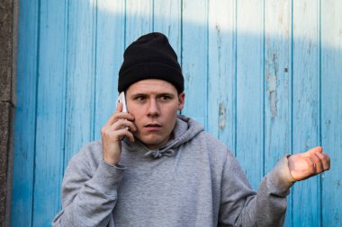 Endişeli ve sinirli genç adam cep telefonuyla konuşuyor.