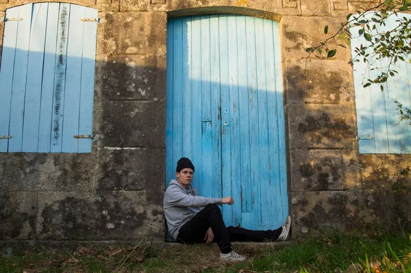Portrait Young Man Sitting Blue Door Background — Φωτογραφία Αρχείου