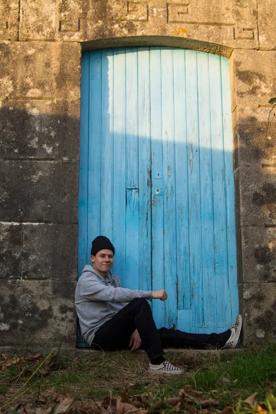 Portrait Young Man Sitting Blue Door Background — Φωτογραφία Αρχείου