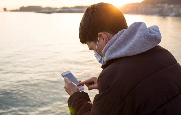 Young Man Medical Mask His Face Using Mobile Phone Ocean — ストック写真