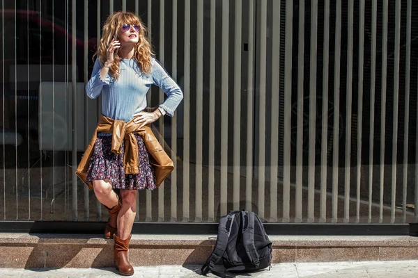 tourist woman with backpack in the city standing talking with the mobile phone