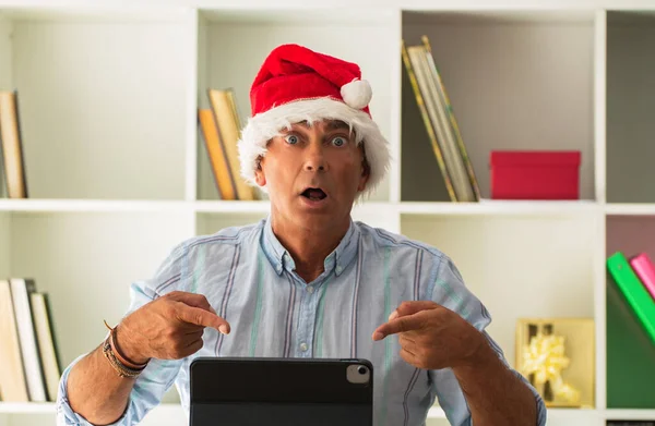 Mann Mit Weihnachtsmütze Verblüfft Mit Überraschungsgeste Beim Blick Auf Laptop — Stockfoto