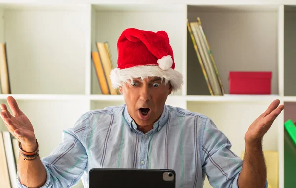 Mann Mit Weihnachtsmütze Verblüfft Mit Überraschungsgeste Beim Blick Auf Laptop — Stockfoto