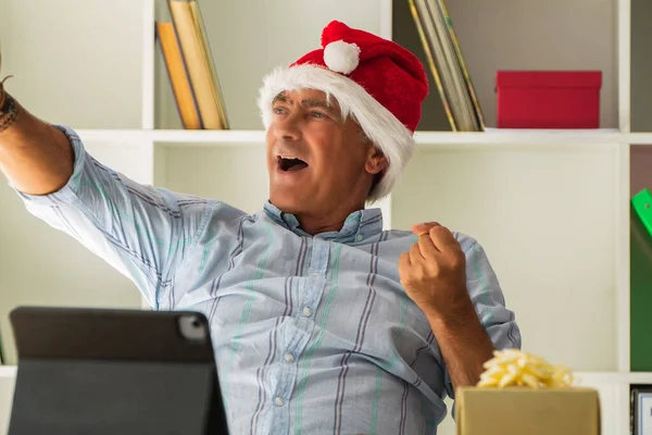 Άνδρας Καπέλο Σάντα Στο Γραφείο Γιορτάζει Χριστούγεννα Χειρονομία Νίκης — Φωτογραφία Αρχείου