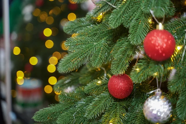Noel ağacını süsleyen yakın plan. Kırmızı toplar ve el feneriyle süslenmiş çelenkler. Yeni yıl makro fotoğrafları yan yana. Kış tatili hafif süslemeleri. Boşluğu kopyala