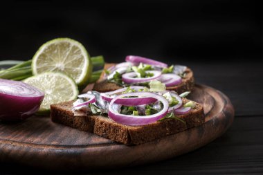 Karadeniz kıymalı, soğanlı ve maydanozlu siyah ekmek sandviçleri. Tahta bir tahta.