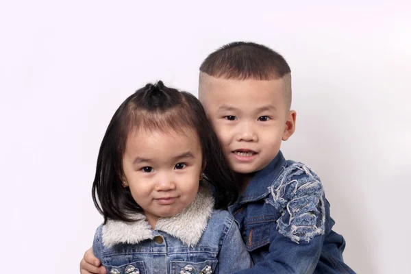 Two Happy Asian Children Hugging Light Background — Stock fotografie