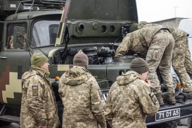 Ukrayna, Odessa, 2022 kışında. Ukrayna ordusunun askeri üniformalı birkaçı askeri teçhizatı tamir ediyor..