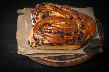 Koyu arkaplanda çikolata parçaları olan tatlı çörek..