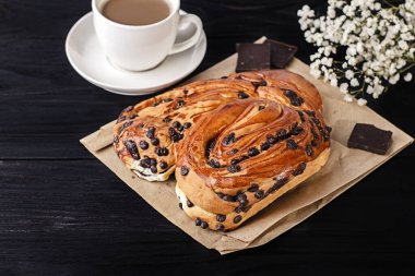 Koyu arkaplanda çikolata parçaları olan tatlı çörek..