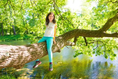 Mutlu kız ağaca tırmanıyor.