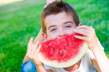 Parkta karpuz yiyen tatlı çocuk.