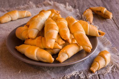 Tahta bir masada taze kruvasan.