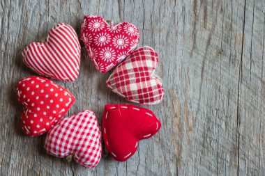 Ahşap arka planda kalp şeklinde kırmızı yastıklar