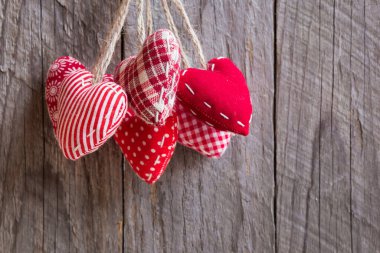 Ahşap arka planda kalp şeklinde kırmızı yastıklar