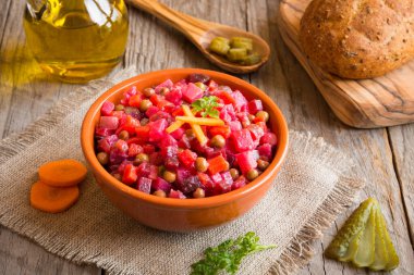 Sebzeli kırmızı mercimek çorbası ve ahşap masada baharatlar.