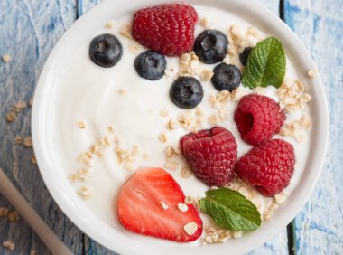 Ahşap arka planda taze böğürtlenli yoğurt.