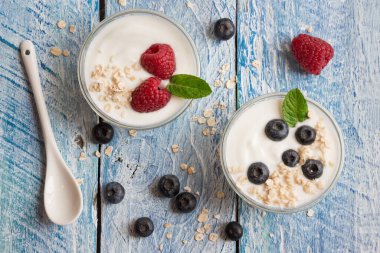 Ahşap arka planda taze böğürtlenli yoğurt.