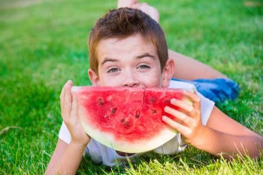 Parkta karpuz yiyen tatlı çocuk.