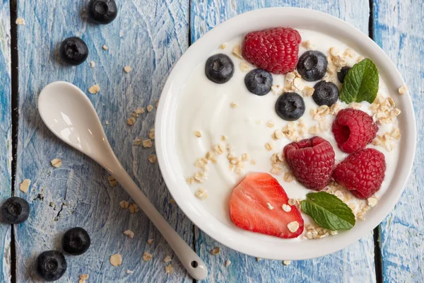 Ahşap arka planda taze böğürtlenli yoğurt.