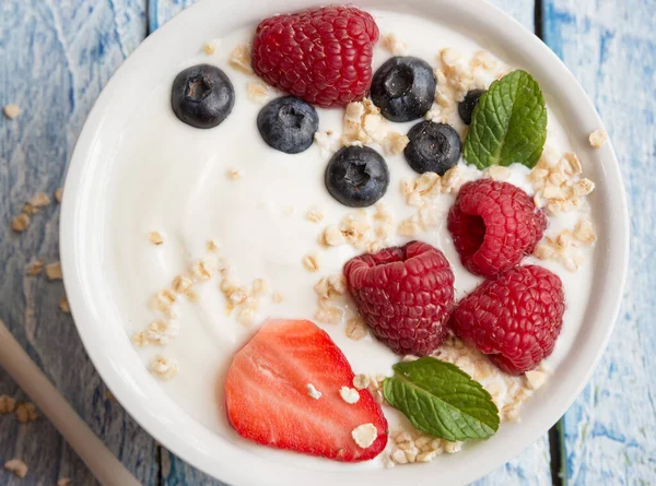 Ahşap arka planda taze böğürtlenli yoğurt.
