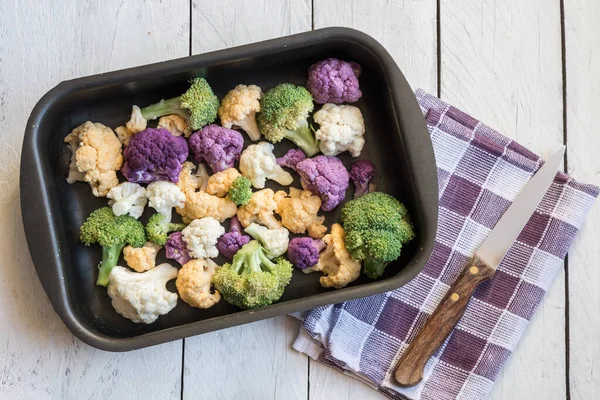 fresh cauliflower and broccoli in a bowl on a wooden background