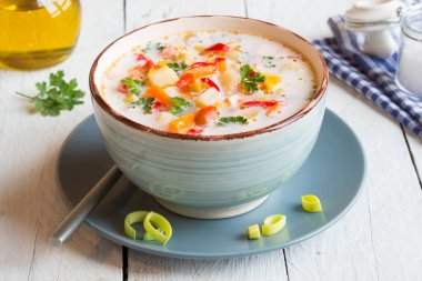 Ahşap arka planda tavuk ve sebzeli çorba.