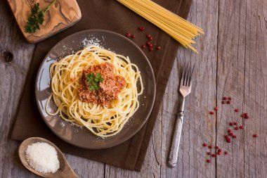 Domates soslu spagetti ve ahşap arka planda parmesan peyniri. en üstteki görünüm.