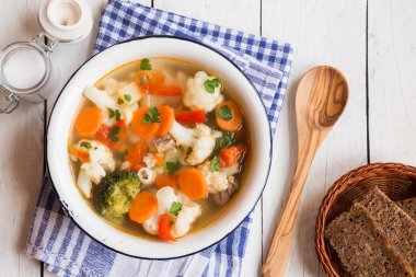 Tavuk ve sebzeli çorba ahşap arka planda