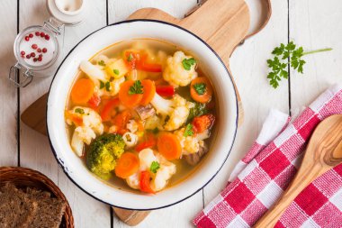 Ahşap arka planda sebzeli ve baharatlı tavuk çorbası. seçici odak.