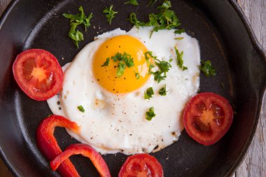 Kızarmış yumurta, domates, soğan ve tavada turpla kahvaltı. 