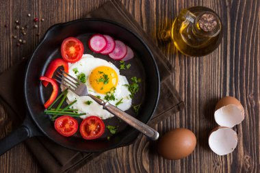 Kızarmış yumurta, domates, soğan ve tavada turpla kahvaltı. 