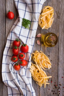 Domates ve fesleğen ahşap arka plan üzerinde ham makarna