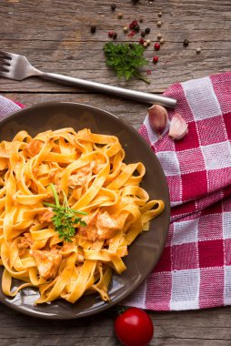 domates soslu makarna ve ahşap arka planda fesleğen yaprakları.