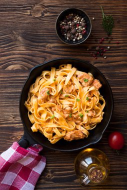 tavuklu makarna ve ahşap arka planda domates sosu.